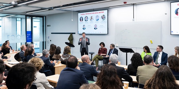 A conference panel discussion with various speakers addressing global trends.