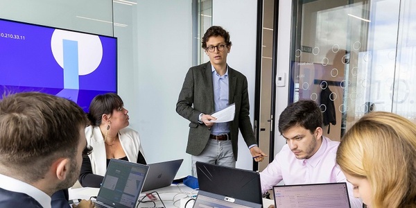 IE Meeting room with a man explaining something to their teammateg