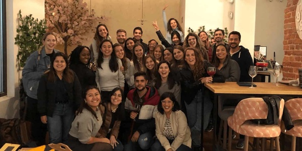 A group of happy people posing for a photo in a cozy indoor setting, likely a casual social gathering or celebration.