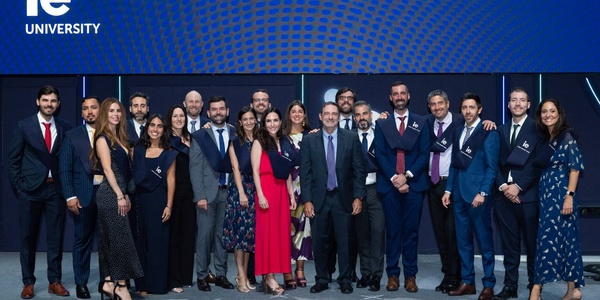 A graduation ceremony group photo with students and faculty members at a university.