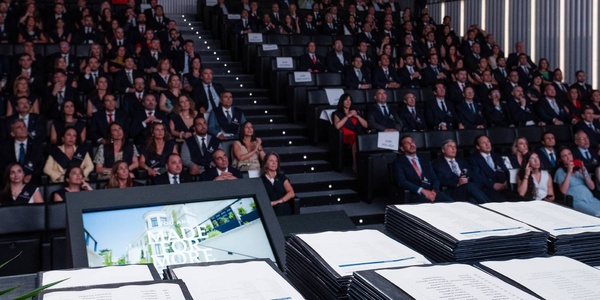 A large audience gathered in a modern auditorium for an event.