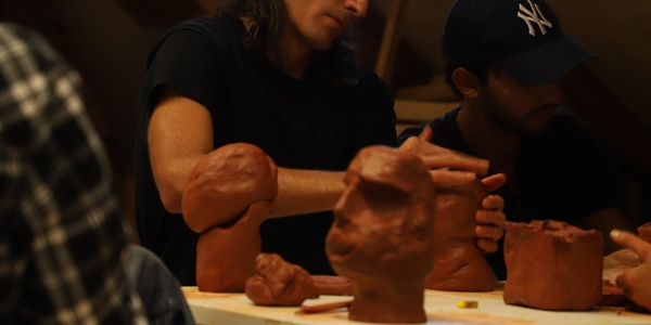 People sculpting with clay at a workshop.