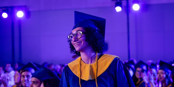 A graduate smiles during a commencement ceremony.
