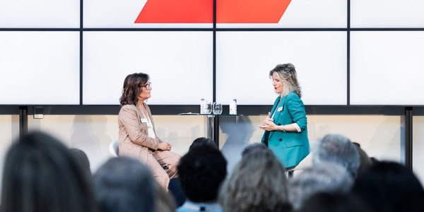 A conversation between two women on stage in front of an audience.