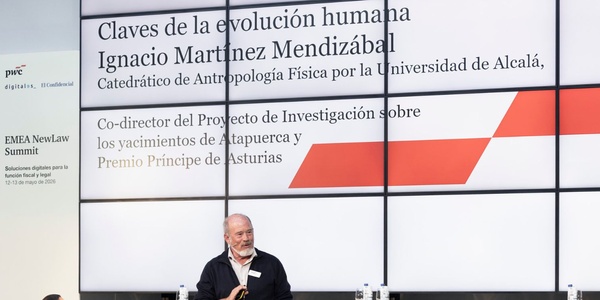 A man is speaking at a conference about human evolution.
