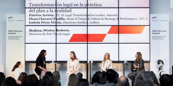 A panel discussion featuring four women discussing legal transformation practices at a conference.