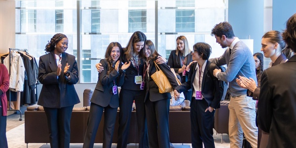 A group of professionals celebrating together in a modern office setting.