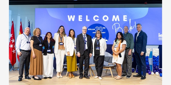 A group of professionals standing together at an event celebrating a 20th anniversary.
