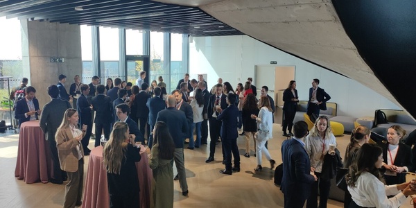 A group of professionals networking in a modern indoor setting with natural light.