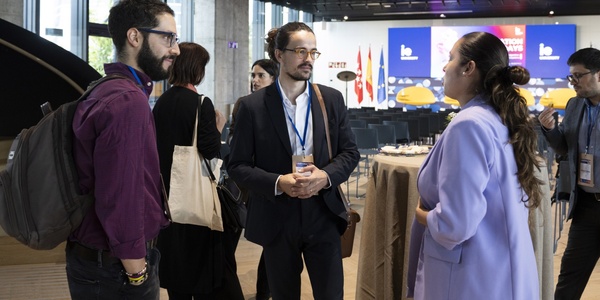 People engaging in a conversation at a conference event.