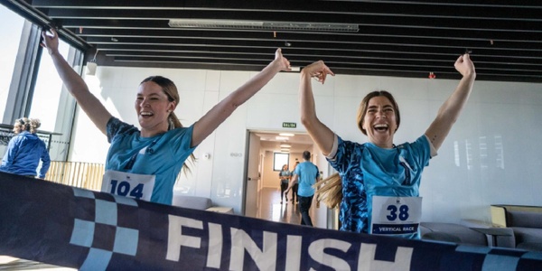 Two athletes celebrate joyfully after crossing the finish line in a competition.