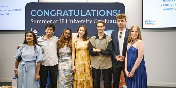 A group of graduates celebrating at an IE University event.