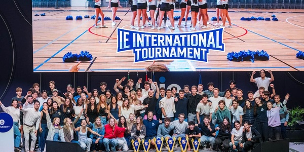 A large group of people celebrating at the IE International Tournament event.