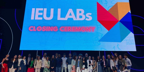 A group of people gathered on stage for the closing ceremony of IEU LABs.