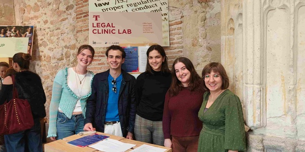 A group of five people standing together at an event focused on legal education.