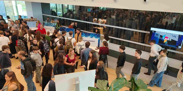 A crowded indoor event featuring many people engaged in conversation and activities.