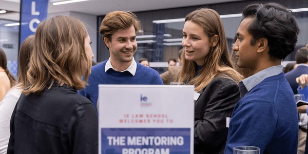 Group of young professionals engaging in conversation at a mentoring program event.