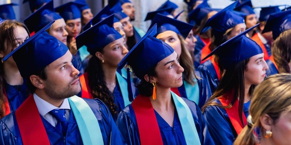 A group of graduates wearing caps and gowns during a ceremony.