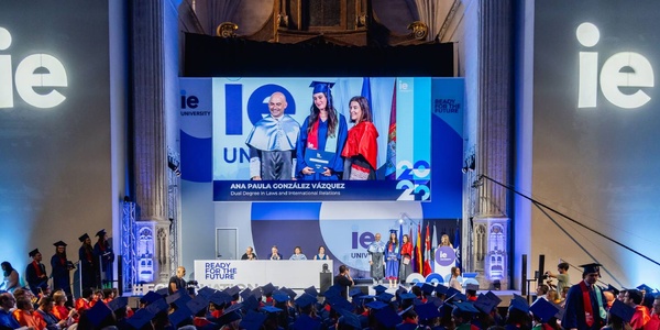 A graduation ceremony showcasing graduates receiving their diplomas on stage.