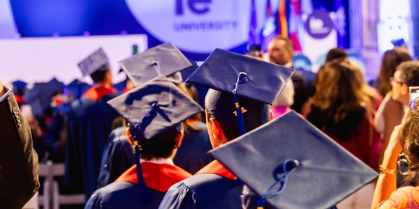 A group of graduates wearing caps and gowns at a university ceremony.