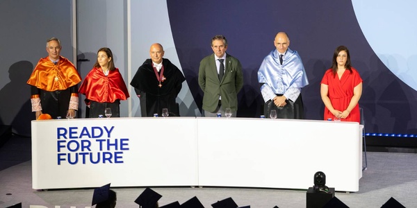 A group of professionals in formal attire standing behind a podium with a backdrop that reads 'READY FOR THE FUTURE'.