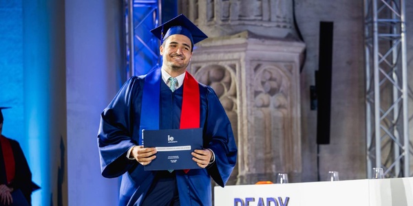 A graduate proudly holding their diploma during a ceremony.