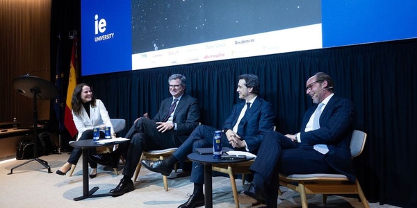 A panel discussion at IE University featuring four speakers.