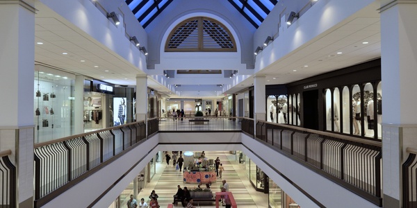 A spacious indoor shopping mall with multiple levels and various stores.