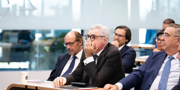 A group of businessmen attentively participating in a meeting.