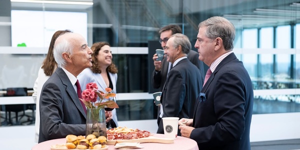 Group of professionals interacting at a networking event in a modern office space.