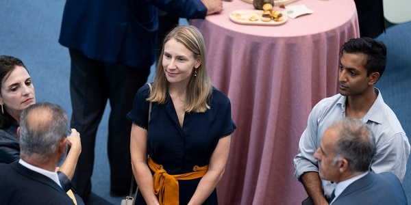 A group of professionals engaged in a conversation at a networking event.