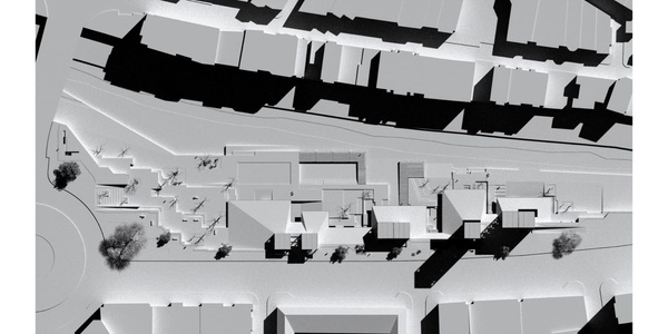 Aerial grayscale image of an urban layout showing buildings and streets.