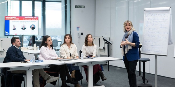 A group of professionals engaged in a discussion during a presentation in a modern office setting.