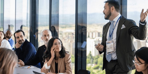 A business presentation in a modern conference room with an engaging speaker and attentive audience.