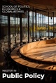 A modern conference room with a circular table and large windows, overlooking nature.