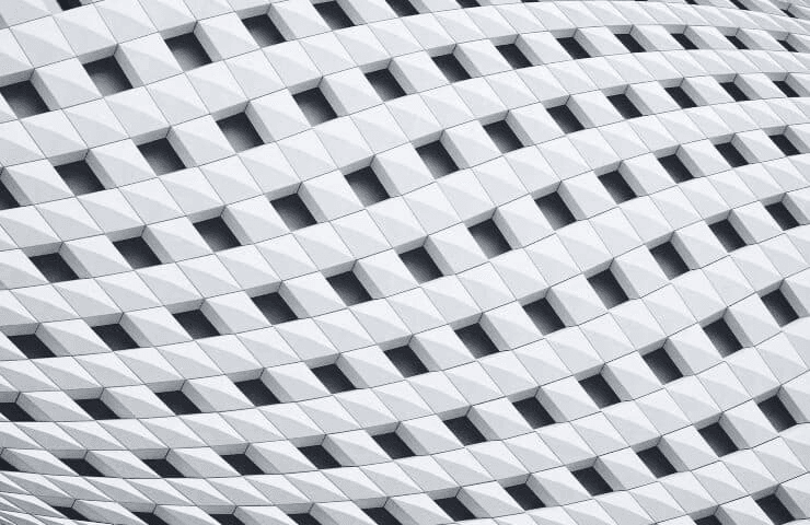 Close-up view of a modern white building facade with a unique geometric pattern.