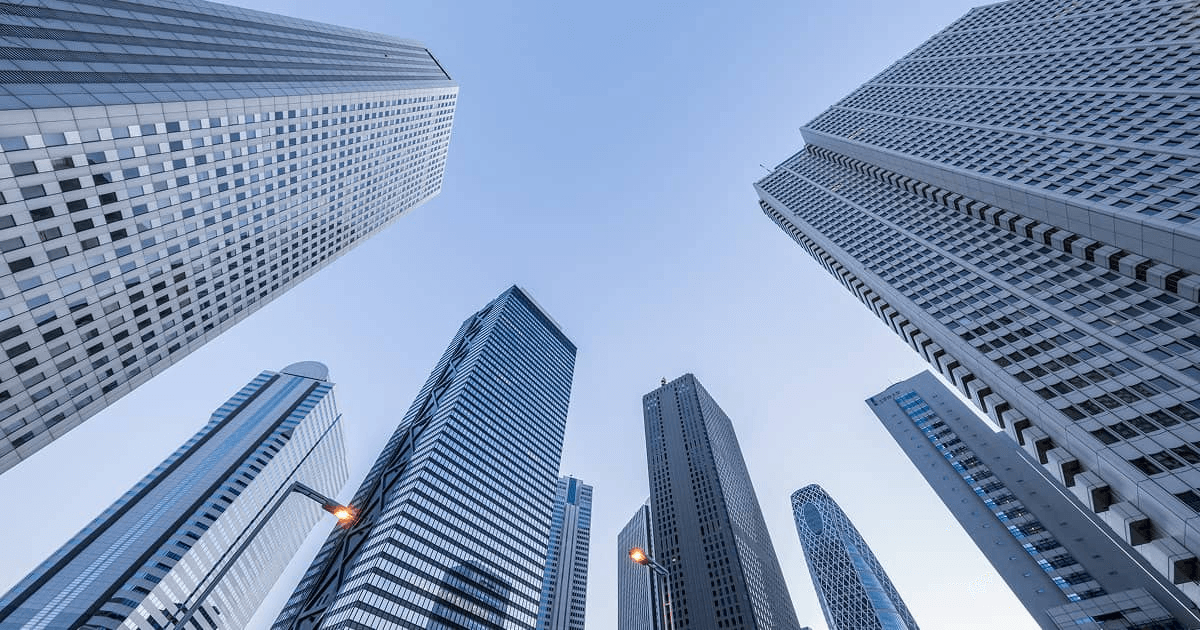 A view looking up at tall skyscrapers against a clear sky.