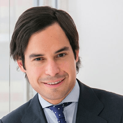 A professional portrait of a smiling man wearing a suit and tie.