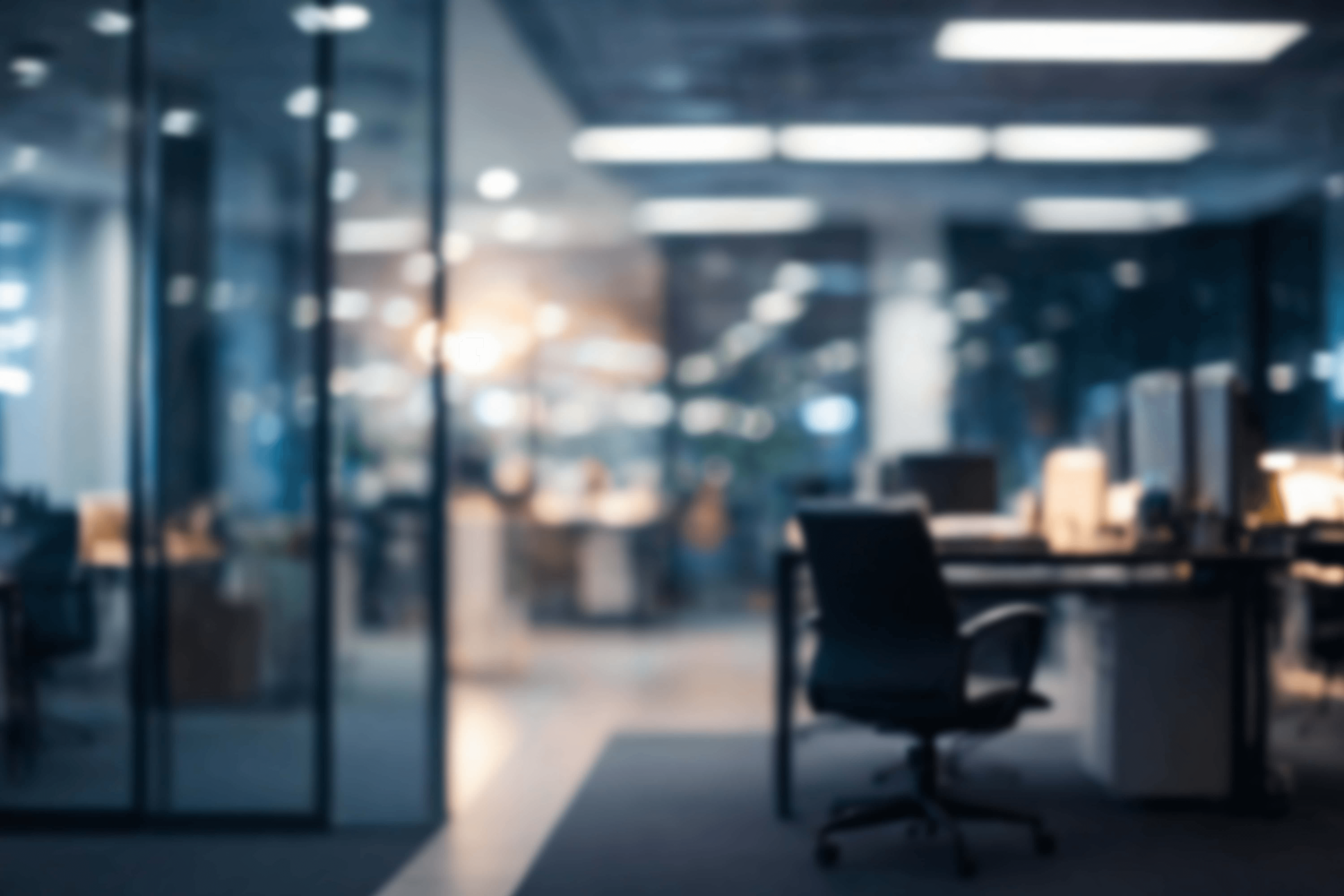 A blurred image of an office interior with a chair and desks in the background.