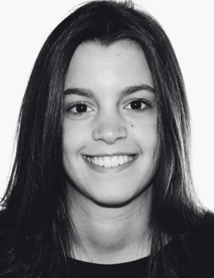Black and white portrait of a smiling young woman with long straight hair.