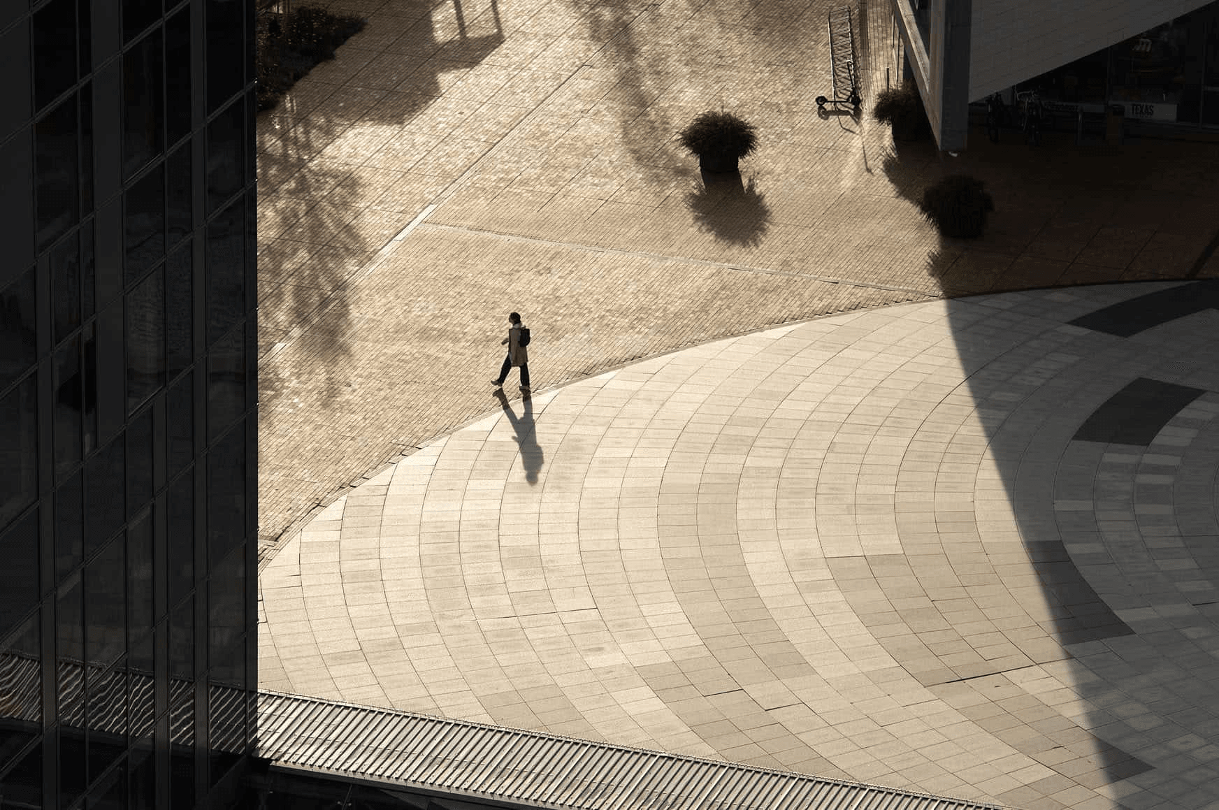 A person walking on a circular pathway in a modern urban environment.