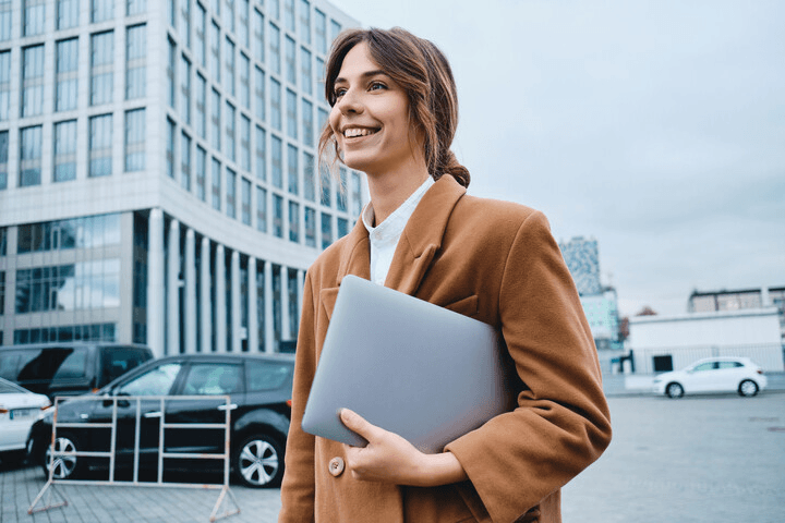Master in management & strategy: woman with a coat and a computer