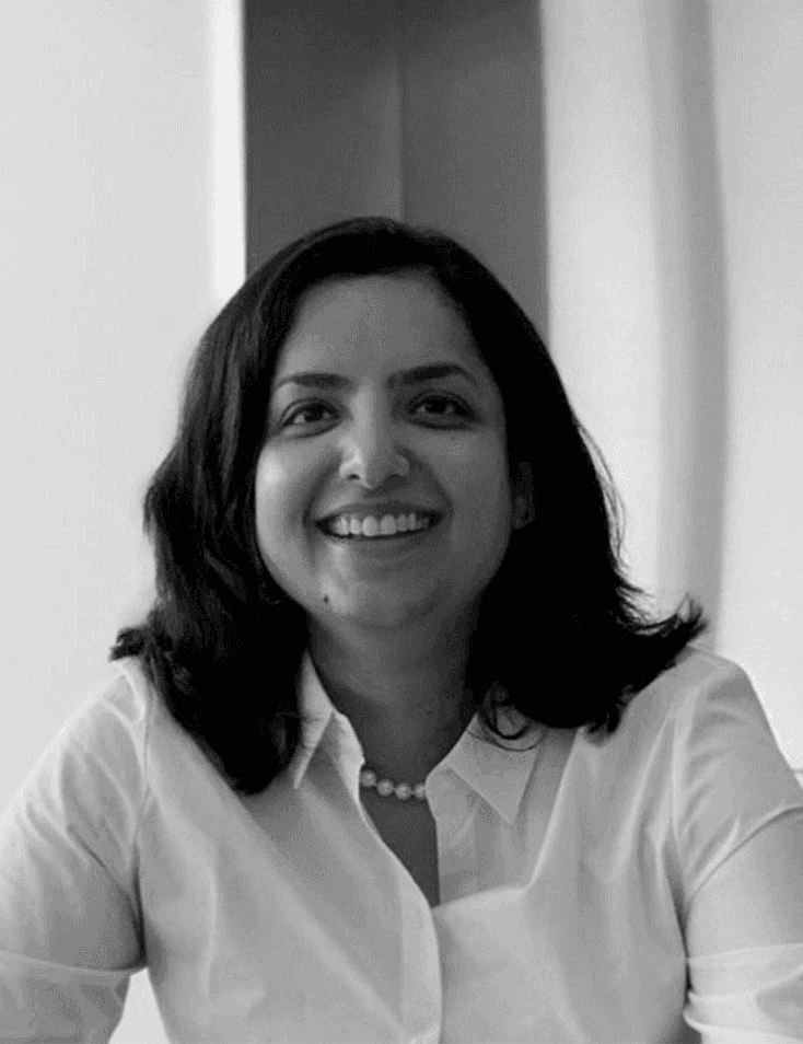 Black and white portrait of a smiling woman in a white shirt.