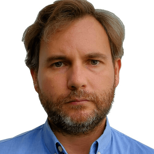 A portrait of a middle-aged man with a beard, wearing a blue shirt.