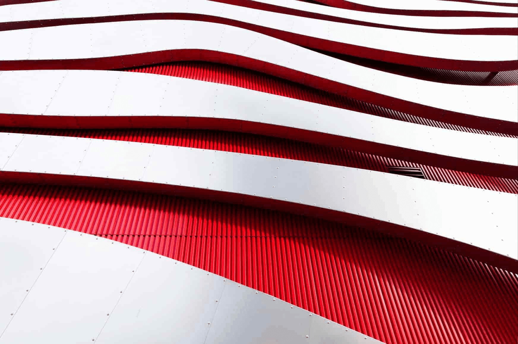 Abstract image featuring red and white curved stripes creating a dynamic and modern visual pattern.