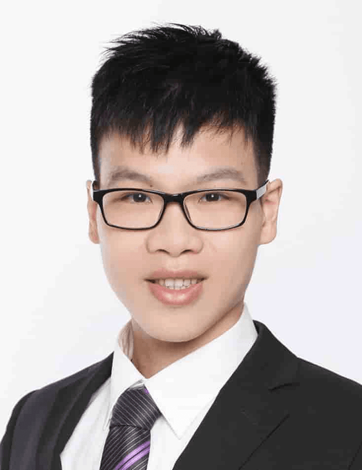 Portrait of a young Asian man wearing glasses, a black suit, and a purple tie on a white background.