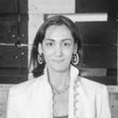 Black and white portrait of a woman wearing earrings and a white blouse.