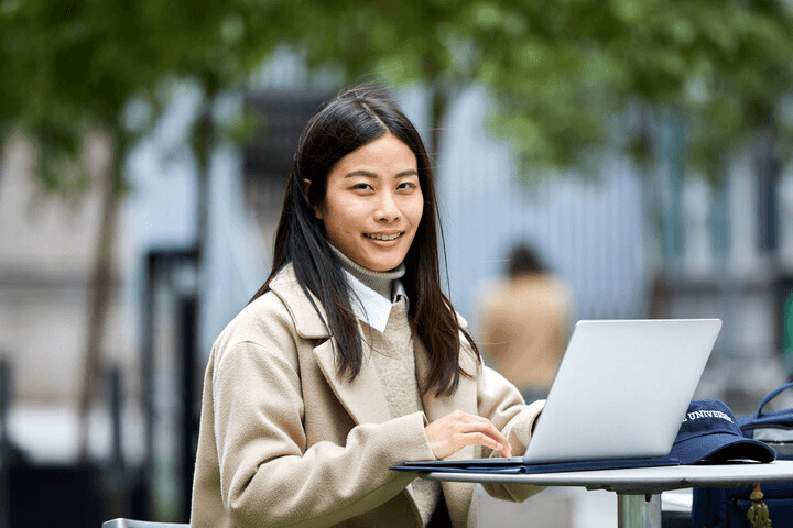 IE Talent Development & Human Resources student with a laptop